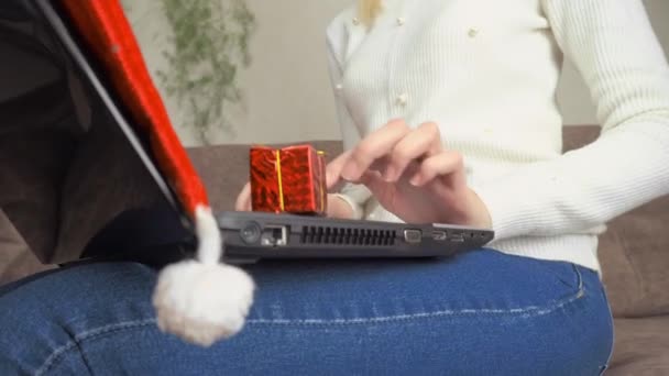 一个女人拿着礼物，在笔记本电脑上打字。网上购物. — 图库视频影像