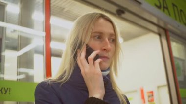 Bir kadın ceketle cep telefonuyla konuşuyor.,