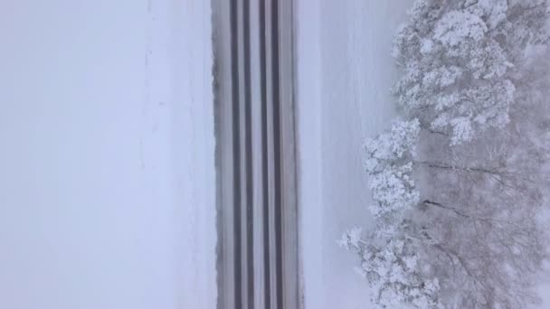 无人机的摄像头被指向下，一条被雪覆盖的冬季道路. — 图库视频影像