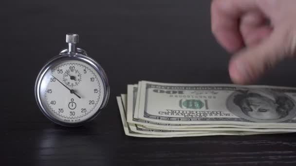 Dollars en een stopwatch. Bedrijfsconcept van tijd en slechte investeringen — Stockvideo