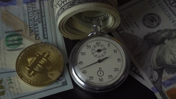 Bitcoin BTC met een stopwatch ligt op dollarbiljetten. — Stockvideo