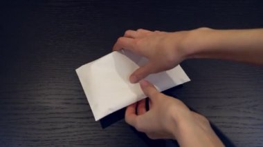 Vergisiz bir zarfın içinde yasadışı bir maaş tutan kadınların elleri. Yakın plan.