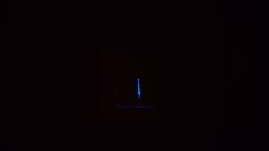 Bir adamın eli duvardaki düğmeyi açıp kapatır ve ışık yanar..