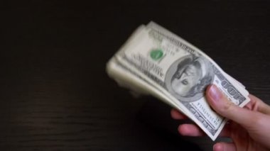Kadınların elleri rastgele sallanır ve bir tomar doları ellerinde gezdirirler..
