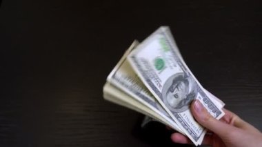 Kadınların elleri rastgele sallanır ve bir tomar doları ellerinde gezdirirler..