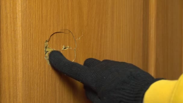 As mãos dos homens em luvas pretas medem um buraco na porta com uma fita métrica, — Vídeo de Stock