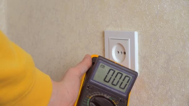 Electrician măsoară tensiunea în prize atunci când lucrează cu tester — Videoclip de stoc