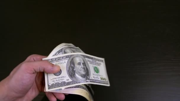 Mužům se ledabyle třesou ruce a listují balíčkem dolarů v rukou,. — Stock video