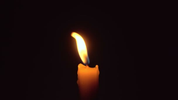 Крупным планом женские руки зажигают свечу спичкой в темноте. — стоковое видео