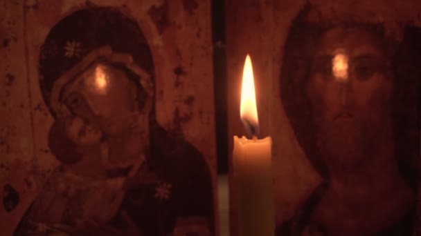 Το χέρι του ανθρώπου ανάβει κερί εκκλησία με το ταίριασμα στο παρασκήνιο ενός εικονιδίου — Αρχείο Βίντεο