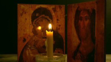 Kilise mumu ikonun arka planında yanar..