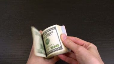 Kadınların elleri rastgele sallanır ve bir tomar doları ellerinde gezdirirler..