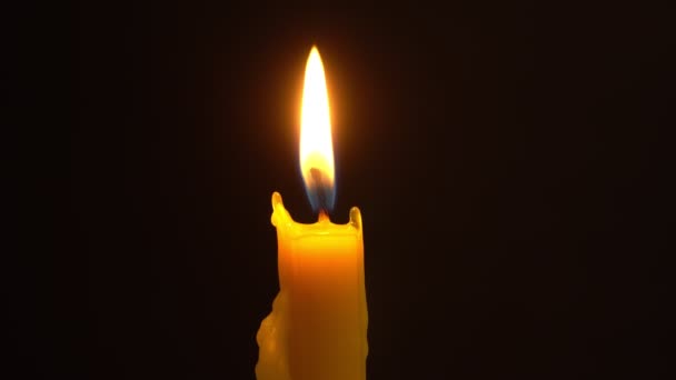 Церковная свеча горит, а рядом висит крест на цепи. Распятый Серебряный Иисус. — стоковое видео