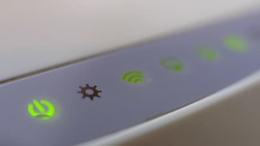 Wi-Fi yönlendiricisi karanlık bir odada yeşil ışık yakıyor..