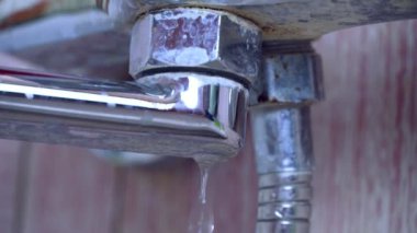 Damlayan eski, paslı musluk, yakın planda..