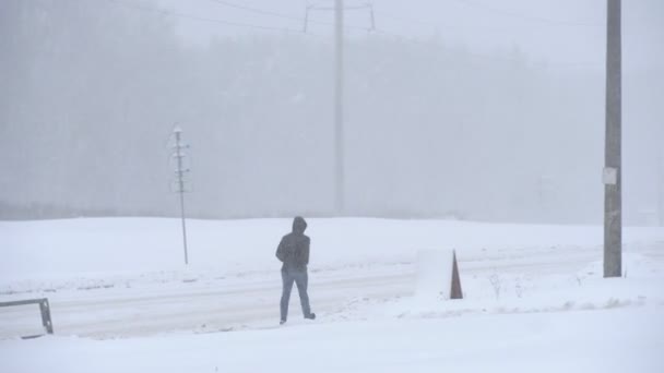 A man walks through the city in winter, in a heavy snowfall. — Stock Video