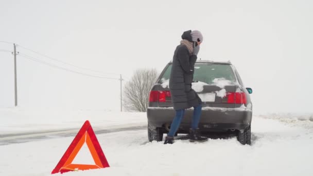 Woman walks around broken-down car and calls on her smartphone — Stock Video