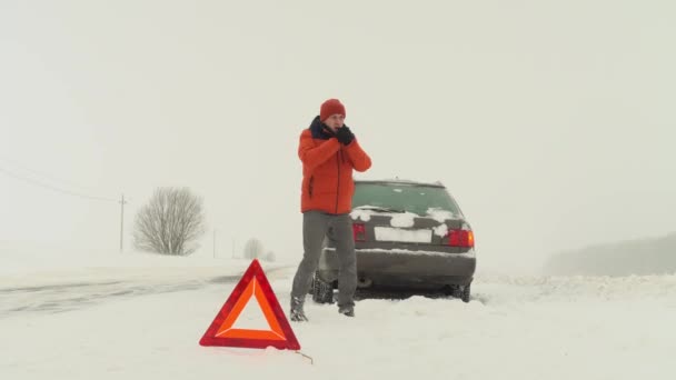 Mannen hoppar från kylan. Hans bil gick sönder på vintern.. — Stockvideo