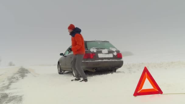 El hombre salta de rabia. Su coche se averió en invierno.. — Vídeos de Stock