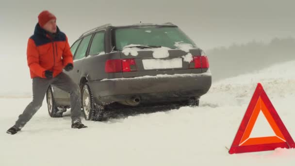 Facet skacze ze złości. Jego samochód zepsuł się w zimie.. — Wideo stockowe