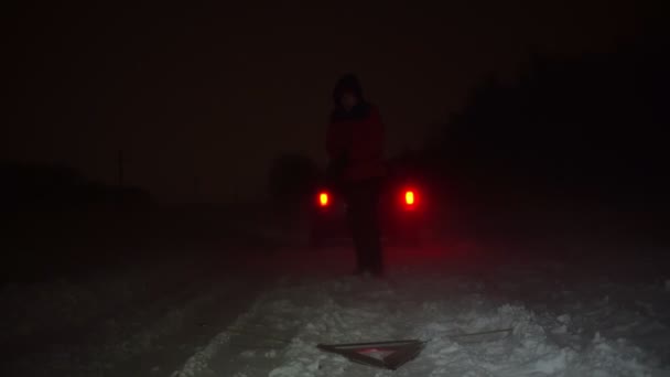 Adam bir kış gecesi arabasının yanına acil durum levhası asmış.. — Stok video