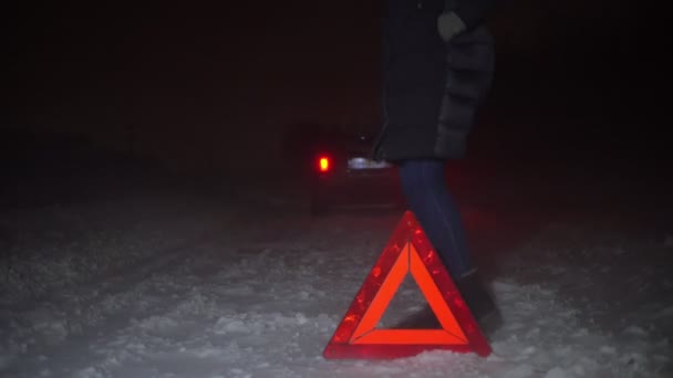 Pigen hopper på stedet fra kulden. Der er nedbrudt bil i nærheden. Nat. – Stock-video