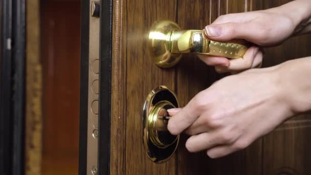 Mujer usando una llave para abrir la cerradura de la puerta principal — Vídeos de Stock