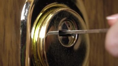 Ön kapının kilidini açmak için anahtar kullanan bir kadın.