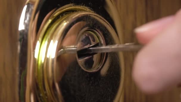 Женщина использует ключ, чтобы открыть замок входной двери — стоковое видео