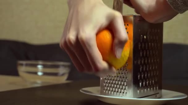 Cocinar frota la ralladura de naranja a mano sobre un rallador — Vídeos de Stock