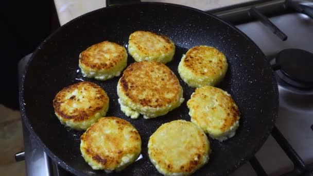 Tortilhas de queijo cottage ou cheesecakes são fritos em uma frigideira quente. — Vídeo de Stock