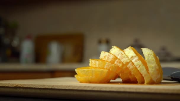 Primer plano de una naranja pelada en rodajas en una cocina casera. — Vídeos de Stock