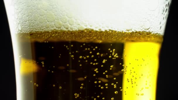 Close-up van bierbelletjes met schuim in een glas. Licht bier. — Stockvideo