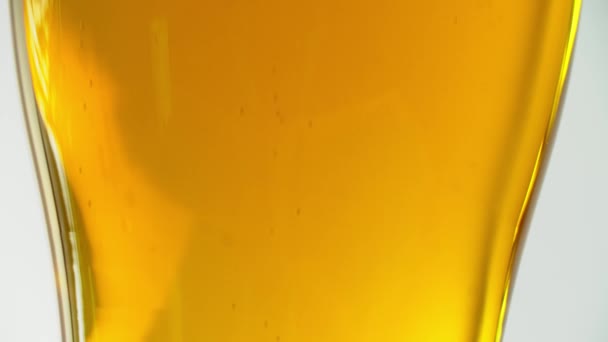 Close-up de bolhas de cerveja com espuma em um copo de vidro. Cerveja light. — Vídeo de Stock