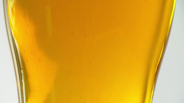 Close-up van bierbelletjes met schuim in een glas. Licht bier. — Stockvideo