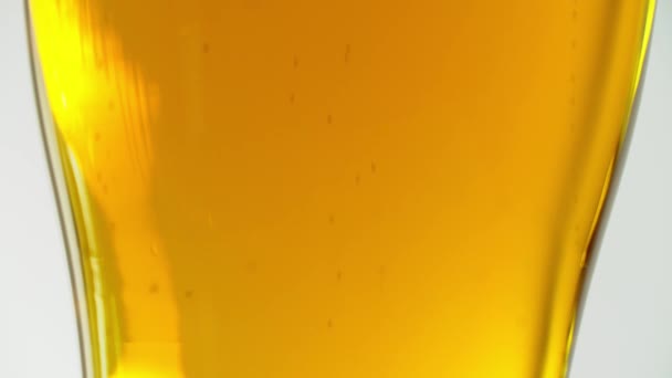 Close-up van bierbelletjes met schuim in een glas. Licht bier. — Stockvideo