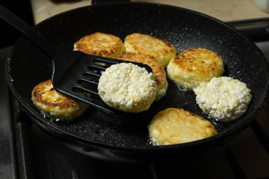 Süzme peynirli krepler siyah bir tavada kahvaltıda kızartılır. Spatulalı süzme peynirli krep.