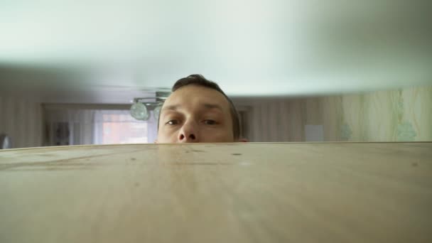 Koncepce úklidu domu. muž utírá prach z vysoké skříňky ve svém domě — Stock video