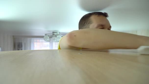 Concept of cleaning the house. a man wipes dust from a tall cabinet in his home — Stock Video