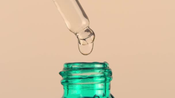 Serum jest pipetowane w szklanej butelce i wlewane do butelki. Białe tło. — Wideo stockowe
