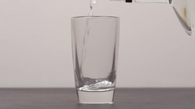 Barmen shot bardaklarına votka ya da tekila dolduruyor.