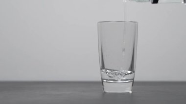 Barmen shot bardaklarına votka ya da tekila dolduruyor.