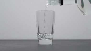 Barmen shot bardaklarına votka ya da tekila dolduruyor.