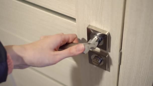 Ręka kobiety z manicure otwiera drewniane drzwi do białego pokoju. Do zamknięcia. — Wideo stockowe