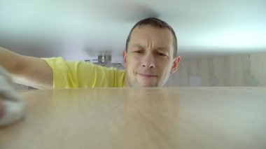 Evi temizleme konsepti. Bir adam evindeki uzun bir dolaptan toz temizler.
