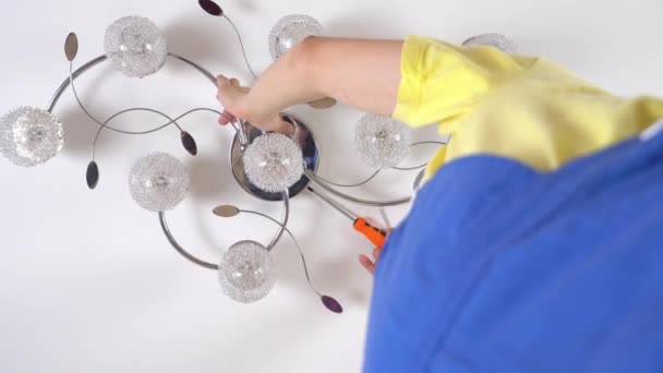Jeune homme électricien, répare un lustre, — Video
