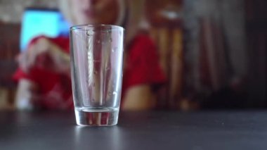 Bir kulüpte ya da restoranda şişeden bardağa alkol döker..