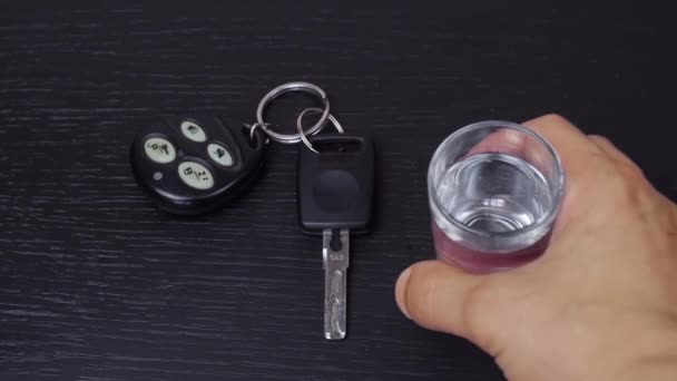 De hand van een man drinkt alcohol en neemt de autosleutels. — Stockvideo