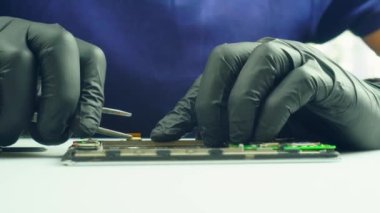 Cep telefonunu tamir eden bir insanın yakın çekimi.