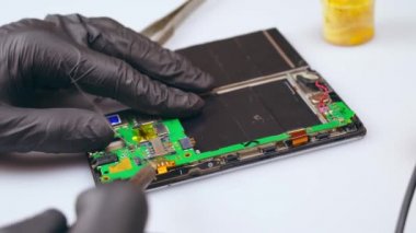 Bir teknisyen elektronik aletleri bir testçiyle tamir eder..